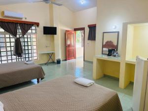 a hotel room with two beds and a television at Cabañas Marisol in Palenque