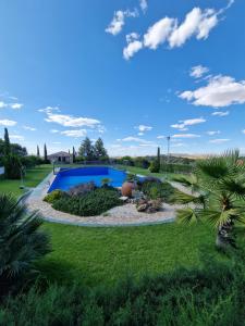 a garden with a swimming pool in the middle at Hotel Atalayas Extremadura in Zafra