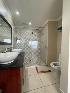 uma casa de banho com um chuveiro, um lavatório e um WC. em Nautica Flat 301 em Mossel Bay