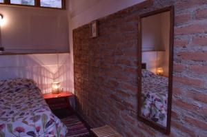 a bedroom with a brick wall and a mirror at Casa en Valparaíso con vista al mar in Valparaíso