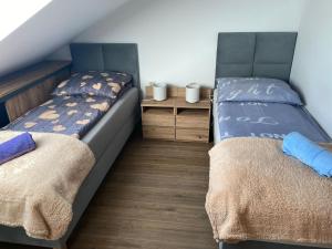 sypialnia z 2 łóżkami i drewnianą podłogą w obiekcie Pensjonat Kaprys w Solcu-Zdroju