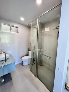 a bathroom with a glass shower and a toilet at I Play Inn NT in Nha Trang