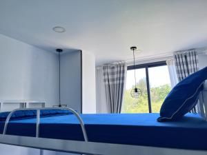 una camera con un letto blu e una finestra di I Play Inn NT a Nha Trang