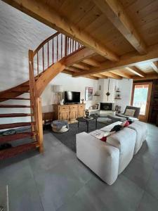 a living room with a white couch and a staircase at Châlet Champex-lac in Champex