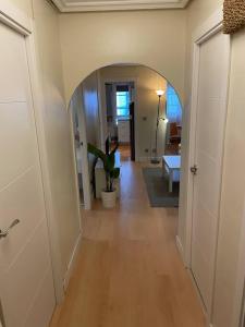 un pasillo con un arco en una casa con una planta en Bonito y acogedor apartamento cerca de Donostia San Sebastián en Lezo