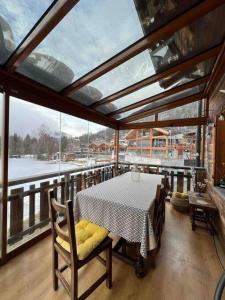 a dining room with a table and a large window at Châlet Champex-lac in Champex