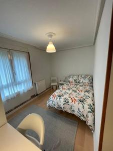 een kleine slaapkamer met een bed en een tafel bij Bonito y acogedor apartamento cerca de Donostia San Sebastián in Lezo