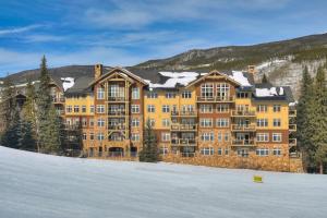 un grande edificio giallo con neve per terra di Timbers & Lone Eagle by Keystone Resort a Keystone