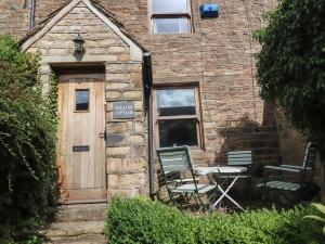 a brick building with a door and a table and chairs at Willow Cottage in Clitheroe