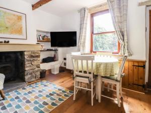 a living room with a table and a fireplace at Willow Cottage in Clitheroe