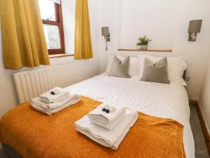 a bedroom with two towels on a bed at Willow Cottage in Clitheroe