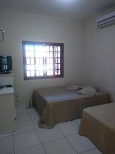 ein Schlafzimmer mit einem Bett und einem Fenster in der Unterkunft Casa Temporada Prainha de Mambucaba Paraty RJ in Paraty