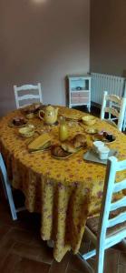 una mesa de comedor con un mantel amarillo con flores en La Cigaliere, en Bézenet
