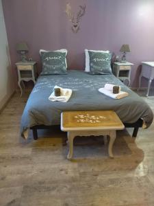 a bed with a table with two cups on it at La Cigaliere in Bézenet
