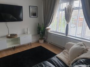 a living room with a couch and a tv at A&S properties, no guest fees, with drive and near city centre in Wolverhampton