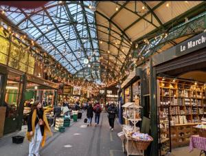 a market with people walking inside of a building at New Tower Bridge , Canada Water 2 bedroom flat with a view in London