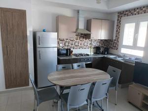 a kitchen with a table and chairs and a refrigerator at VILLA TILEL AYADI Ridha in El Ahmar