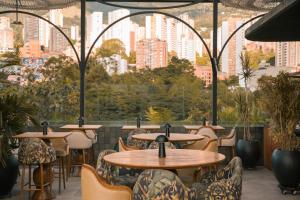 a restaurant with tables and chairs and a view of the city at Selvario 36 Hotel in Medellín