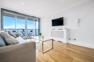 a living room with a couch and a glass table at Stunning Flat on King's Road, Chelsea with Balcony in London