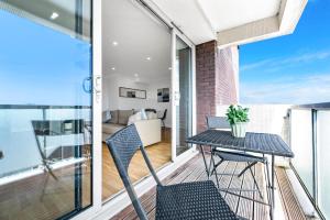 a balcony with a table and chairs and a living room at Stunning Flat on King's Road, Chelsea with Balcony in London