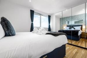 een slaapkamer met een groot wit bed en een groot raam bij Stunning Flat on King's Road, Chelsea with Balcony in Londen