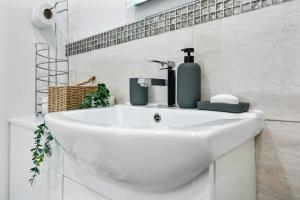 a white bathroom sink with a soap dispenser on it at Stunning Flat on King's Road, Chelsea with Balcony in London