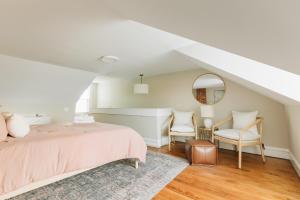a bedroom with a pink bed and two chairs at Quaint Boho Home in Lancaster City in Lancaster