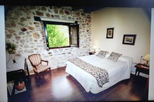 um quarto com uma cama e uma parede de pedra em Apartamentos Rurales Larrago em Busturia