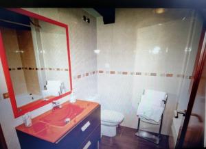 uma casa de banho com um lavatório vermelho e um WC. em Apartamentos Rurales Larrago em Busturia