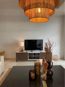 a living room with a television and a chandelier at Lägenhet med 3 sovrum i sagolika byn - LaHeredia in Benahavís
