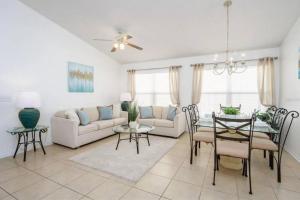 a living room with a couch and a table and chairs at Spacious Vacation Home Near Disney w/ Private Pool- Perfect for Families! in Davenport