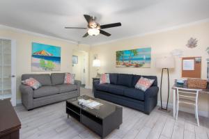 a living room with two couches and a ceiling fan at Clearwater Beach Suites 204 condo in Clearwater Beach