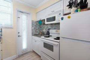 cocina con electrodomésticos blancos y nevera blanca en Clearwater Beach Suites 204 condo, en Clearwater Beach