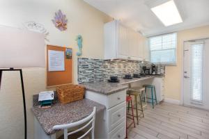 cocina con armarios blancos y encimera en Clearwater Beach Suites 204 condo, en Clearwater Beach