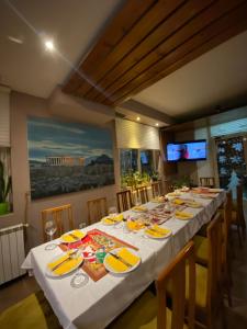 een lange tafel met borden en servetten erop bij Hotel Akropoli in Tirana
