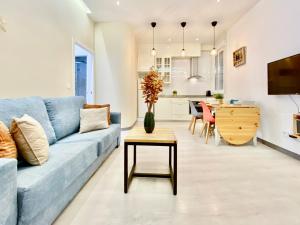 ein Wohnzimmer mit einem blauen Sofa und einem Tisch in der Unterkunft Charming Puerta del Sol Center - 6 Bedrooms in Madrid