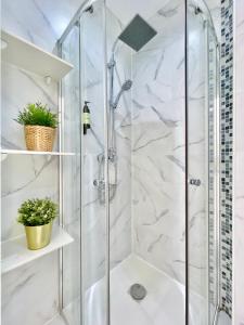 y baño con ducha y paredes de mármol blanco. en Charming Puerta del Sol Center - 6 Bedrooms, en Madrid