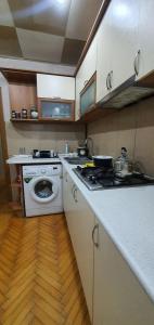 a kitchen with a stove and a washing machine at Уютная трехкомнатная квартира с видом на море в Баку in Baku