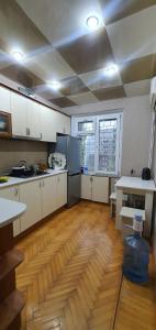 a kitchen with white cabinets and a wooden floor at Уютная трехкомнатная квартира с видом на море в Баку in Baku