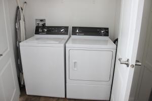 Lavadora y secadora blancas en una habitación pequeña en Beautiful Rental Just North Of Durango, en Hermosa