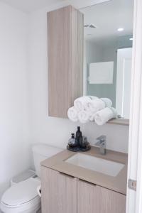 een badkamer met een wastafel, een toilet en een spiegel bij Modern luxury Waterfront Condo in Mississauga