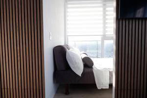 Modern luxury Waterfront Condo في ميسيساوغا: غرفة نوم بسرير وكرسي مع نافذة