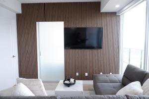 a living room with a couch and a tv on a wall at Modern luxury Waterfront Condo in Mississauga