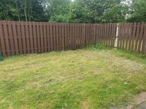 une clôture en bois avec une cour herbeuse à côté de celle-ci dans l'établissement A&S properties, no guest fees, with drive and near city centre, à Wolverhampton
