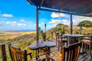 una terraza con mesas y sillas y vistas a las montañas. en Hotel Punta Descartes, en La Cruz