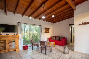 sala de estar con sofá rojo y TV en Mar & Campo en Santa Teresita