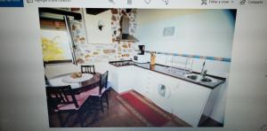 Una pequeña cocina con una mesa y un fregadero. en Apartamentos Rurales Larrago, en Busturia