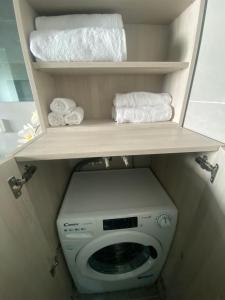 a bathroom with a toilet and towels on a shelf at Serendipity Living in Kythira