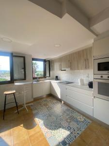 eine Küche mit weißen Schränken und einem Teppich auf dem Boden in der Unterkunft Casa frente al mar con Vistas in Oliva