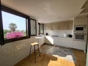 eine Küche mit einem Fenster und einem Hocker darin in der Unterkunft Casa frente al mar con Vistas in Oliva